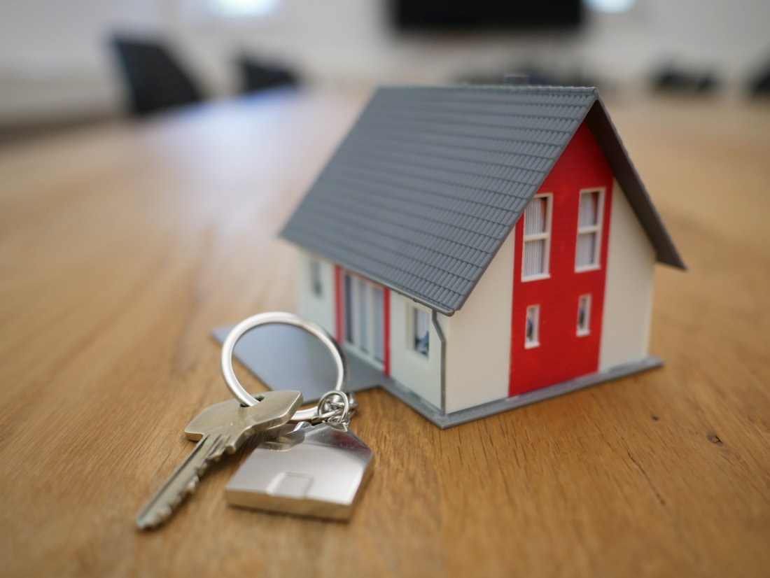 Immobilienplanung mit Hausmodell und Schlüsseln